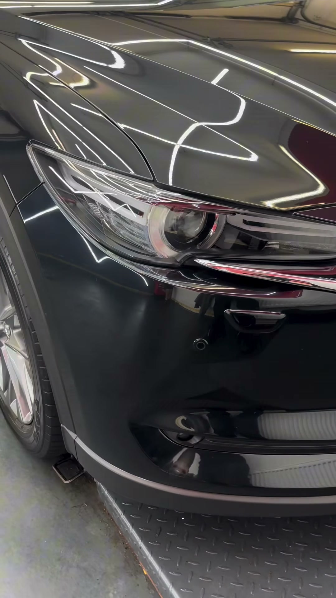 Glänzende Front und Scheinwerfer eines schwarzen Mazda CX-5